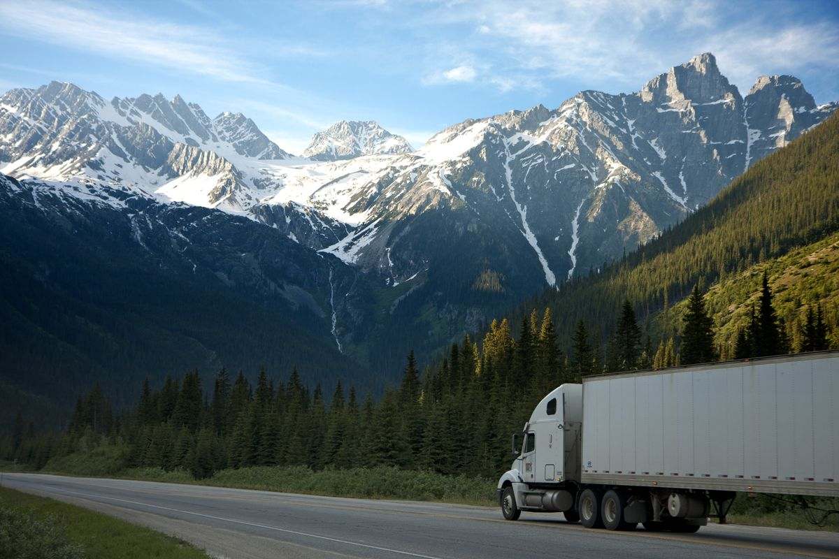 A fleet of trucks parked with mountains in the background